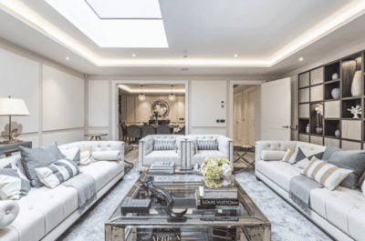 A living room with white couches and a skylight.