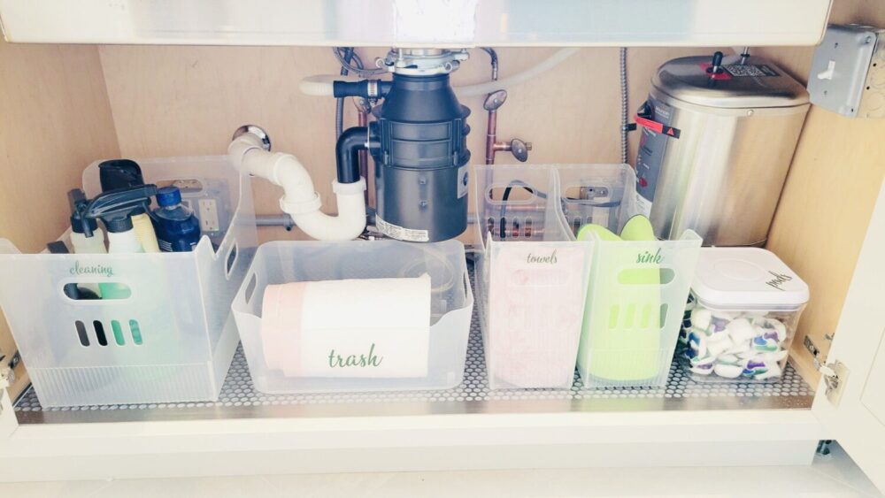 A kitchen sink with a sink and a sink full of cleaning supplies.