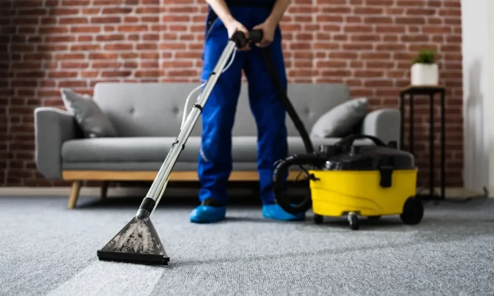 Professional-Carpet-Cleaning-in-London A man is vacuuming a carpeted floor.